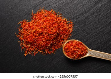 saffron spice inside of ceramic spoon  on black stone background - Powered by Shutterstock