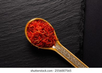 saffron spice inside of ceramic spoon  on black stone background - Powered by Shutterstock