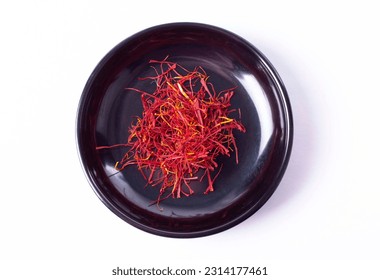 Saffron Strands in Small Black Bowl in Top Down or Flat Lay View Isolated on White - Shutterstock ID 2314177461