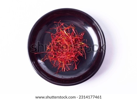 Saffron Strands in Small Black Bowl in Top Down or Flat Lay View Isolated on White
