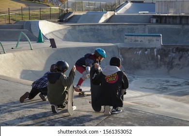 Sagae, Yamagata / Japan - November 16, 2019: Kids In A Skate Park Helping Another Young Skater Skate A Ramp For The First Time.