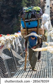 SAGARMATHA NATIONAL PARK, NEPAL - MARCH 18: Porters Carry Heavy Load In The Himalaya On March 18, 2014 In Sagarmatha National Park, Nepal