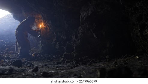 Sage Man Examining Cave Walls