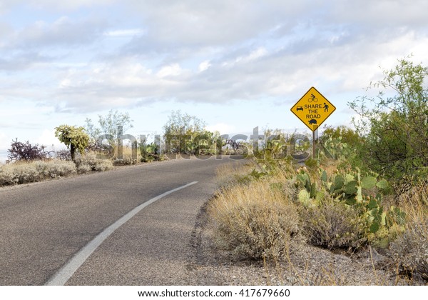Saguaro National Park East\'s multiuse sign reflects\
Share the Road philosophy.  Cactus Forest Loop Drive is used by\
cars, bikers, hikers, and wildlife. Location is Tucson, Arizona,\
USA.