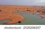 Sahara Desert lake in Merzouga desert , water in dunes and people tourism enjoying camel ride 