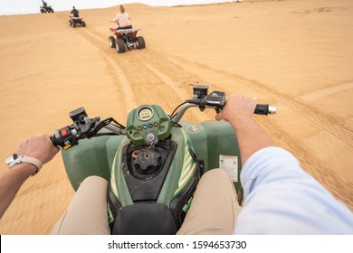 SAHARA, TUNIS - MAY 26, 2019: Point Of View Shoot Of Man Driving Quad Bike At Sandy Sahara Desert In Africa. Horizontal Color Photography.