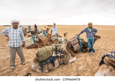 SAHARA, TUNIS - MAY 26, 2019: Entertainment For Tourists. Riding Camels In Desert At Sandy Sahara In Africa. Horizontal Color Photography.