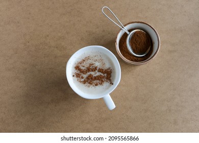 Sahlep, milk and orchid roots hot drink in a white cup with cinnamon. Local name is "salep". Wooden background. Drink concept and idea.