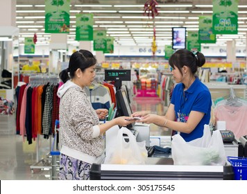 Saigon, Vietnam - Jul 22, 2015. A Female Cashier Of The Coopmart Supermarket Is Giving A Woman Her Receipt For The Products That She Just Bought And Paid In Saigon, Vietnam..