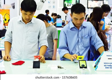 SAIGON, VIETNAM - OCTOBER 8 : people who are testing new phones in Saigon Shopping Center, this mall accommodates many famous brand names and one of the largest in the city, in October 8, 2013