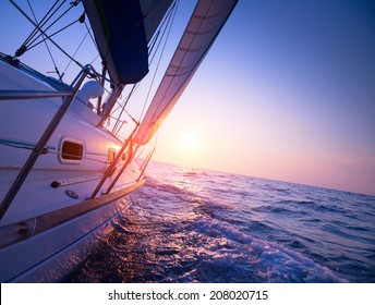 Sail Boat Gliding In Open Sea At Sunset