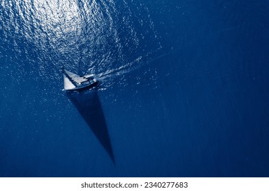 Sail boat sailing on a blue ocean.