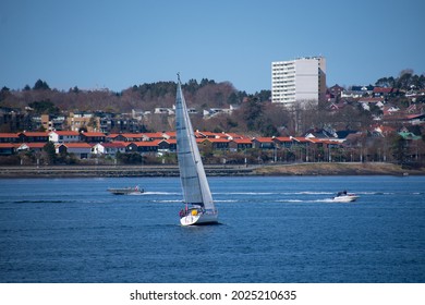 Sail Boat And Speed Boat With Small Coastal City (Stavanger Norway) In The Background