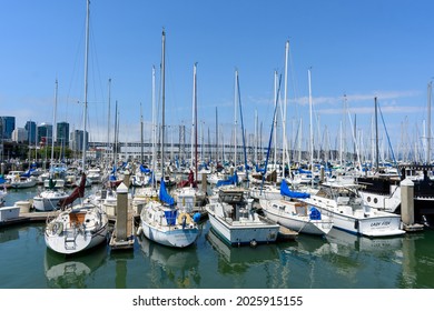 Sail boats and yachts docked at South Beach Harbor Marina. Background span of San Francisco - Oakland Bay Bridge - San Francisco, California, USA - 2021