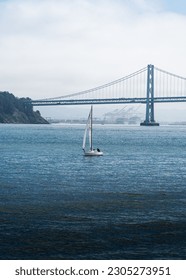 A sail yacht near the famous Oakland bay bridge in San Francisco