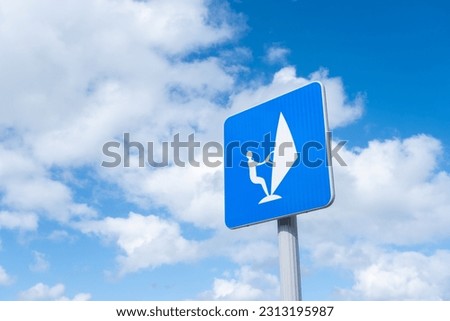 Sailboard sign over blue sky with clouds