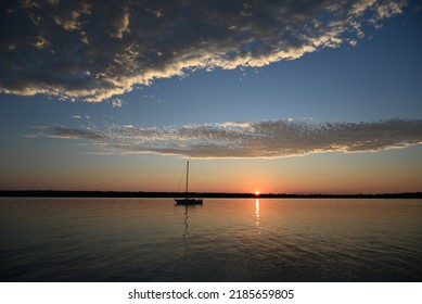 A sailboat anchored off South Twin Island in Lake Superior during sunset at the Apostle Islands National Lakeshore. - Shutterstock ID 2185659805
