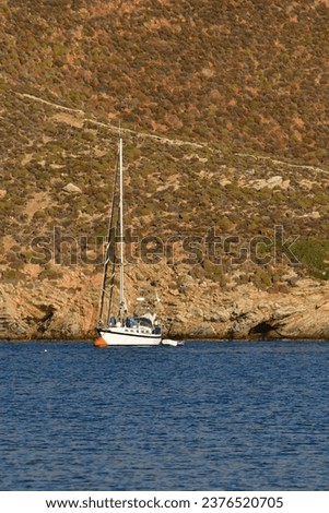 Sailboat in bay of greek island kalymnos blue brown. High quality photo