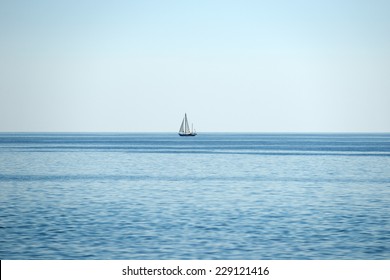 Sailboat With Blue Sea And Sky With Horizon