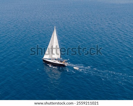Sailboat cruising on a vast blue ocean.