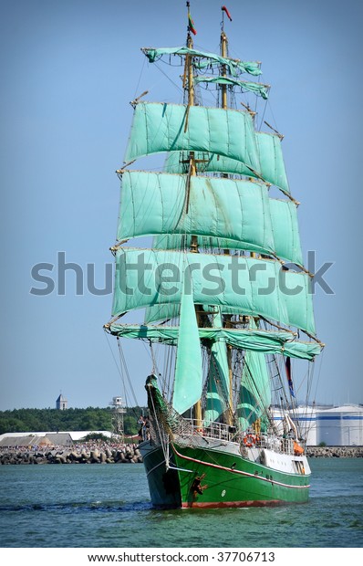 sailboat going out\
of port with full sails\
up