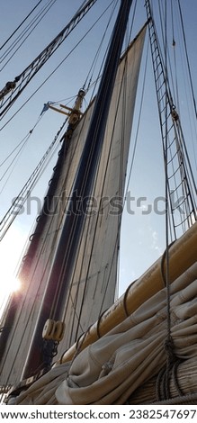 Sailboat mast low angle with sun and sky in the background