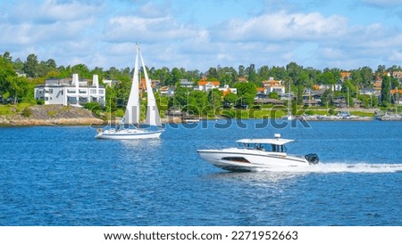Sailboat and a motorboat by the shore of the Swedish Archipelago on a sunny day