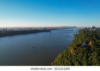 A Sailboat On The Hudson River With Distant NYC And GW Bridge