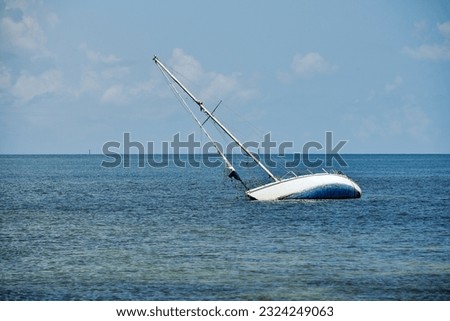 A sailboat runs aground and sinks in the shallow waters around Key West