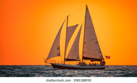 Sailboat Or Sail Yacht. Private Cruise. Sunset Tour. Summer Vacations On Ocean Or Gulf Of Mexico Florida. Yachting Sport. Beautiful Seascape. Red Sky After Sunset. Good For Travel Agency Or Post Card.