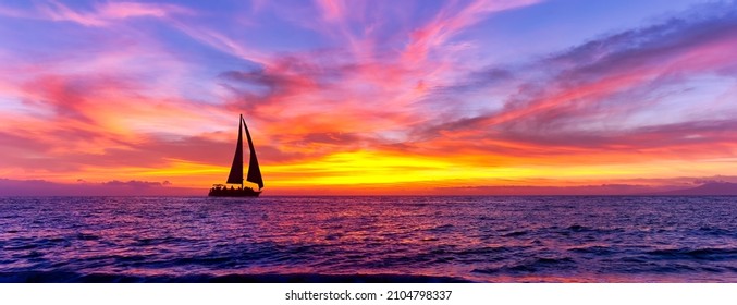 A Sailboat Is Sailing Along The Ocean Against A Colorful Sunset Sky - Powered by Shutterstock