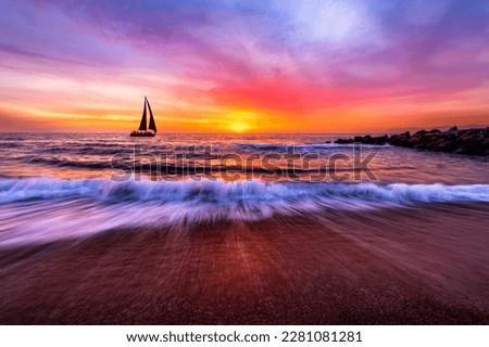 A Sailboat Is Sailing Along The Ocean With A Wave Breaking On Shore