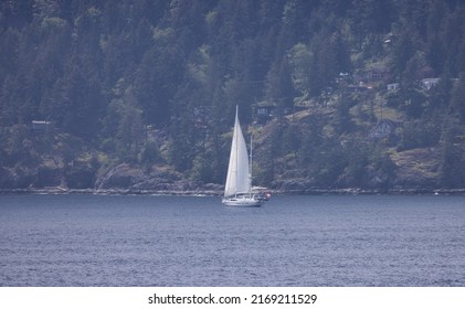 Sailboat sailing by Bowen Island in Howe Sound. Near Vancouver, British Columbia, Canada.