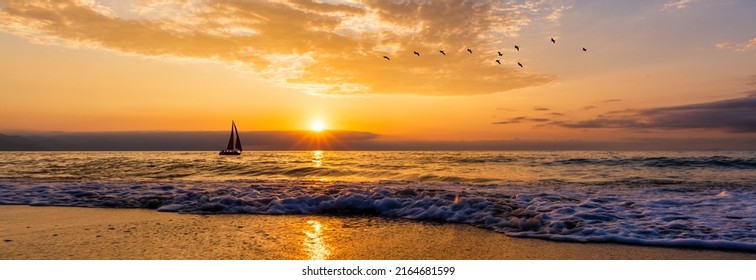 A Sailboat Silhouette Sailing Against A Colorful Sunset Sky And A Flock Of Birds Flying Overhead In Banner Image Format