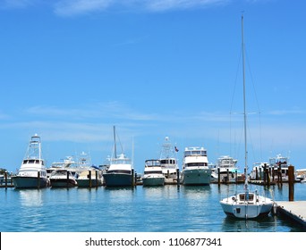 A Sailboat, Yachts And Sportfishing Boats Docked In The Historic Key West Seaport.