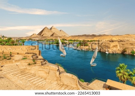Sailboats and ancient rocks in the Nile on the way to pyramids, Aswan, Egypt