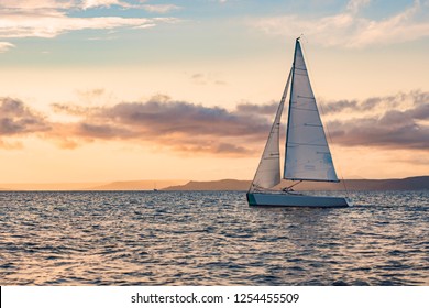 Sailboats on the background of the sunset over the sea