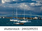 Sailboats and pleasure crafts are docked within sight of the Newport Pell bridge, connecting Jamestown and Newport, Rhode Island