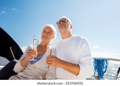 sailing, age, travel, holidays and people concept - happy senior couple with champagne glasses on sail boat or yacht deck floating in sea - Powered by Shutterstock