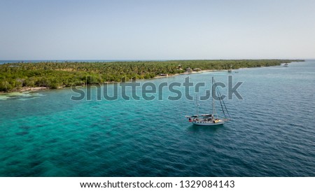 A sailing boat anchored in blue water sea with the island Islas de San Bernardo of the Atlantic coast of Colombia Foto d'archivio © 