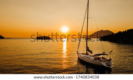 Sailing boat in the Mediterranean sea during scenic sunset.Luxury yacht and cruise holiday.Regatta sailing ship yachts with at opened sea. Aerial view of sailboat in windy condition.