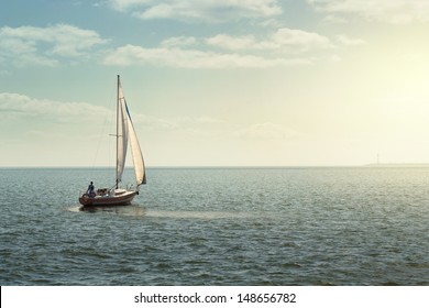 Sailing Boat On The Open Sea At The Sunset