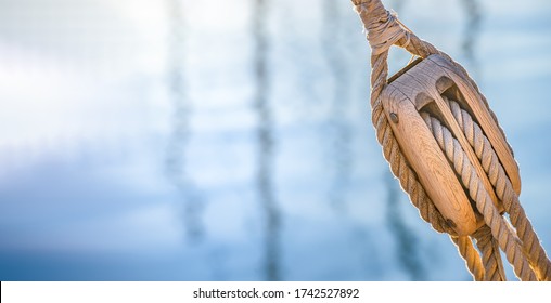 Sailing boat pulley, block and tackle with nautical rope. Nautic water panoramic background.