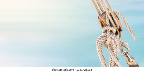 Sailing boat pulley, block and tackle with moored nautical rope. Panoramic water nautic background with copy space.
				