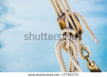 Sailing boat pulley, block and tackle with moored nautical rope.