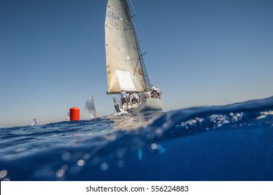 Sailing boat with red buoy from the waterline view