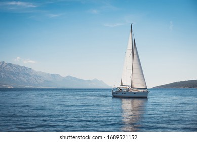 Sailing boat in the sea against the backdrop of mountains	 - Shutterstock ID 1689521152