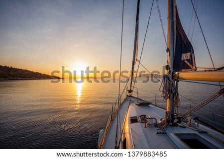 Sailing boat in the sea during awesome sunset. Luxury yacht and cruise holiday.