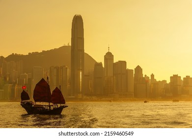 Sailing boat in Victoria harbor of Hong Kong city under sunset