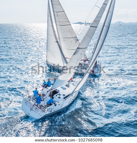 Sailing boats from bird view crossing open sea